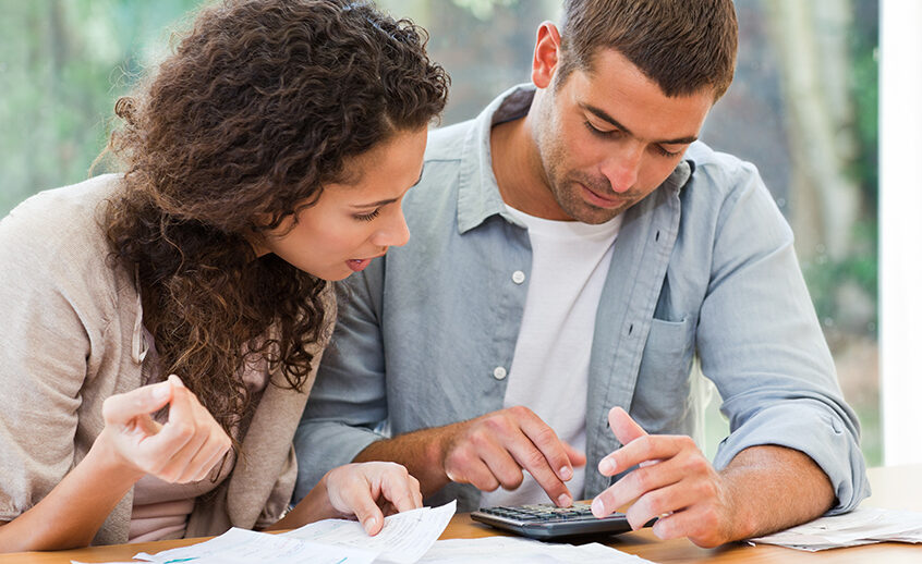 Photo of man and woman reviewing what to avoid when buying a home