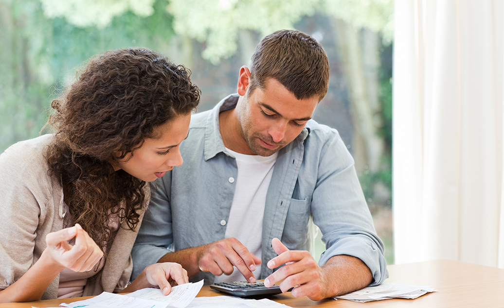 Photo of man and woman reviewing what to avoid when buying a home