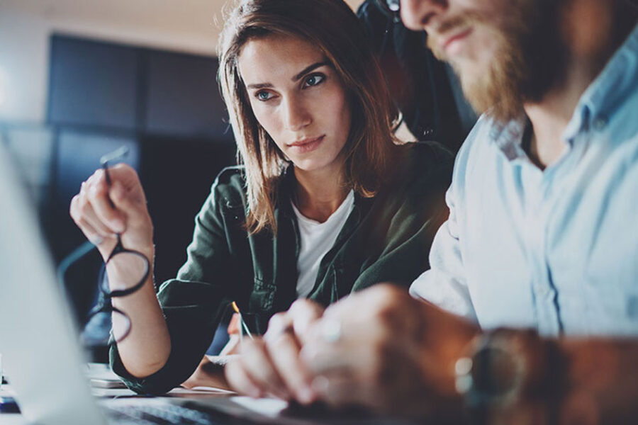 Business Woman And Man Intently Viewing Computer Screen