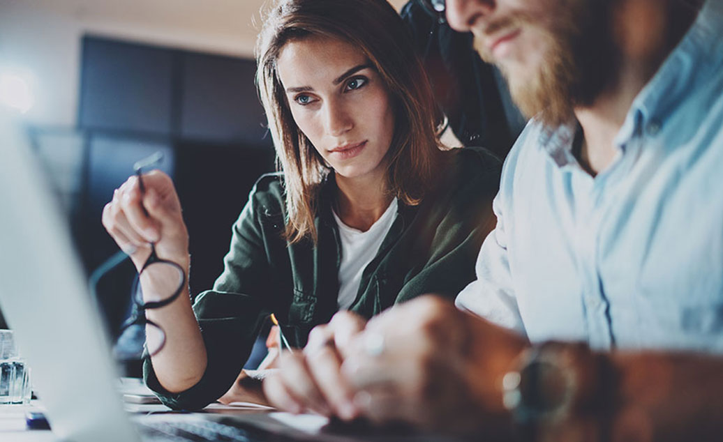 Business Woman And Man Intently Viewing Computer Screen