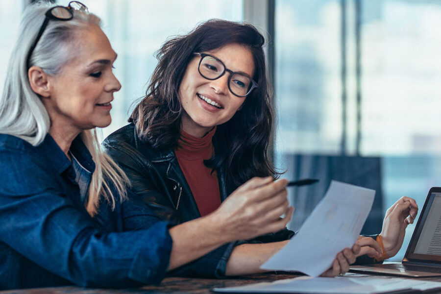 Business Insurance Blog Feature Image Of Two Business Owners Looking At Papers