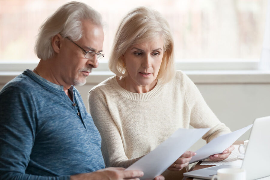 Holiday Scams Blog Feature Photo Of Senior Couple Reviewing Statements
