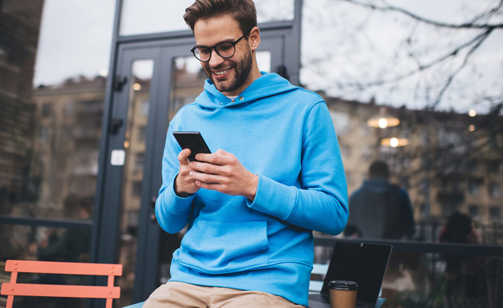 Man using smartphone for digital banking and online services with Bank Midwest.